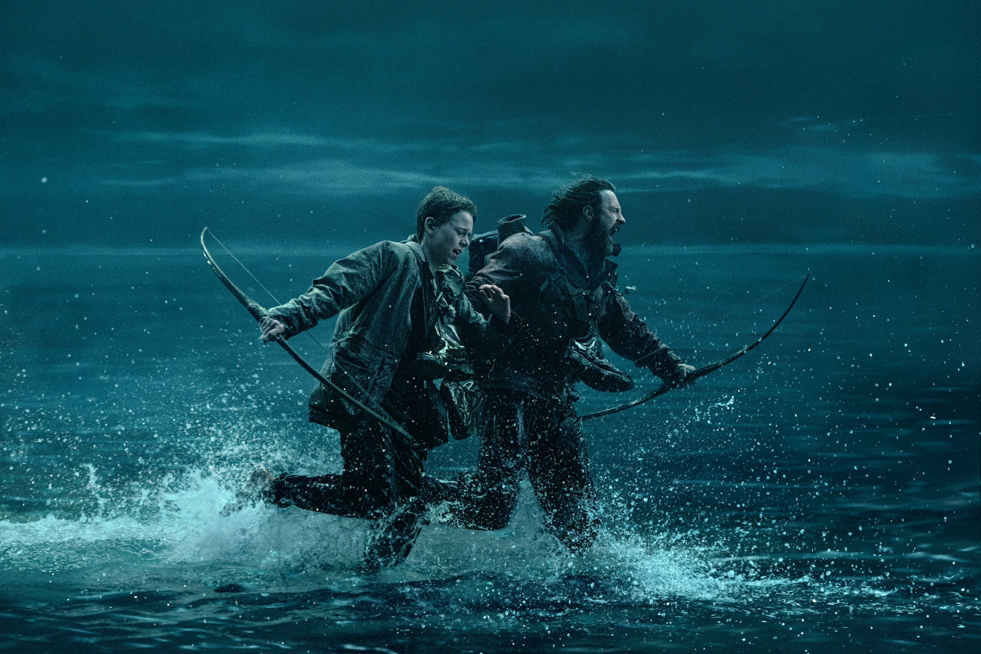 Jamie (Aaron-Taylor Johnson) and Spike (Alfie Williams) crossing a body of water in 28 Years Later | Photo courtesy of Columbia Pictures