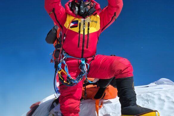Jeno Panganiban holds up the Century Tuna flag at the summit of Mount Everest